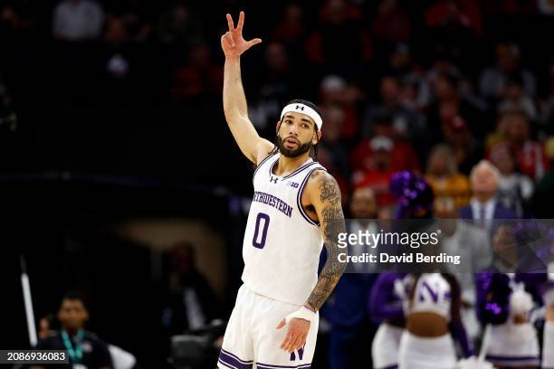 Boo Buie of the Northwestern Wildcats celebrates his three-point basket against the Wisconsin Badgers in the first half at Target Center in the...