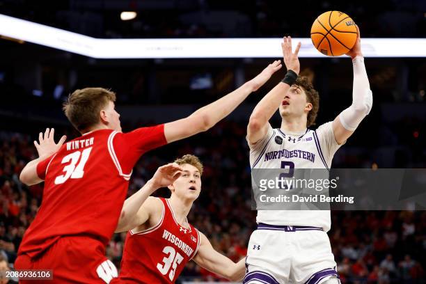 Nick Martinelli of the Northwestern Wildcats goes up for a shot against Markus Ilver and Nolan Winter of the Wisconsin Badgers in the first half at...