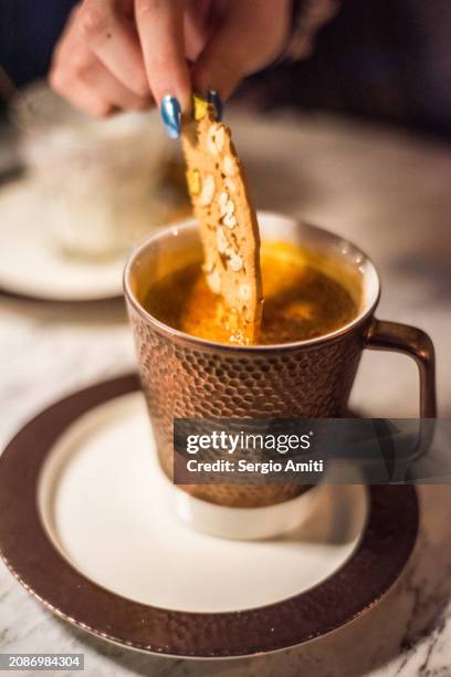 dipping an almond biscotti in a qatari chai halib with saffron - dipping stock pictures, royalty-free photos & images