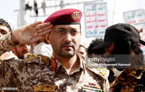 Yemen's Houthi military spokesperson salutes as he attends a protest staged in solidarity with Palestinians against Israel's ongoing war in the Gaza...