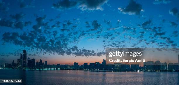 abu dhabi skyline at sunrise - abu dhabi skyline stock pictures, royalty-free photos & images