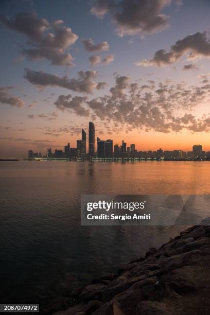 abu dhabi skyline at sunrise - abu dhabi skyline stock pictures, royalty-free photos & images