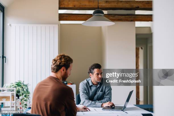 two professionals engaged in a business discussion at a modern office - roupa descontraída imagens e fotografias de stock