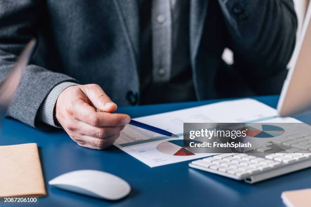 professionale analisi dei grafici finanziari sulla scrivania con la penna - consulenza fiscale foto e immagini stock