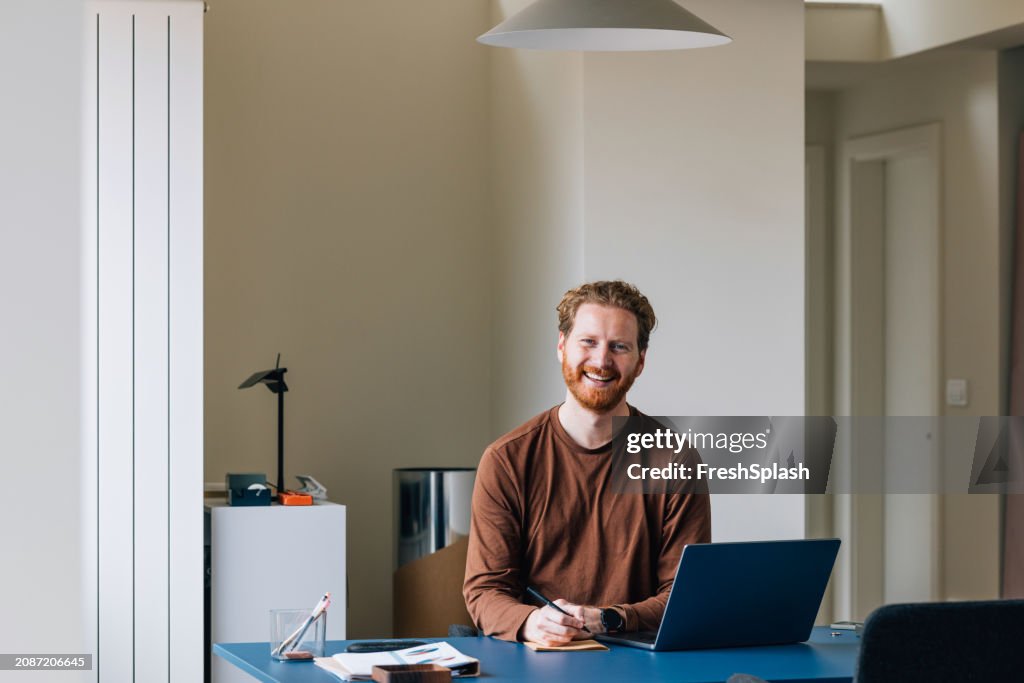 Smiling Businessman with Laptop in Bright Home Office Setting