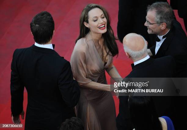 French president of the Festival Gilles Jacob and director Thierry Fremaux welcome US actor Brad Pitt and actress Angelina Jolie arrive for the...