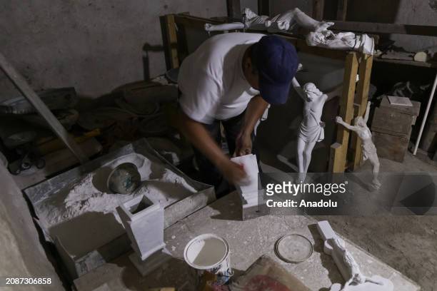 Hugo Menjivar, Salvadoran sculptor and assistant to Roberto Mena, prepares a work of sculpture in the workshop during the work in the family business...