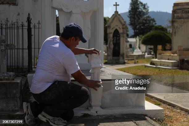 Hugo Menjivar, Salvadoran sculptor and assistant to Roberto Mena, places a piece of sculpture on a family tomb during work at the family business...