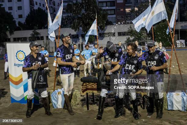 The Cavalier team, winners of the Open Horseball Argentina final, uncork a bottle of champagne to celebrate at the Regimiento de Granaderos a...