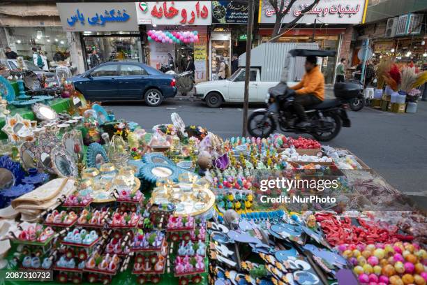 Motorcyclist is riding past decorations for the Haftseen table, the main symbol of the Iranian New Year, in downtown Tehran, Iran, on March 17, 2024....