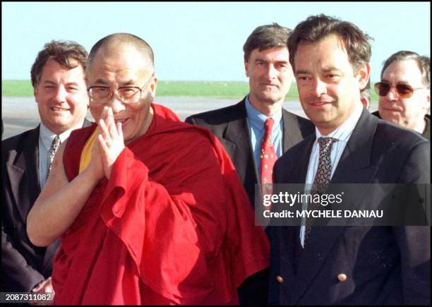 Le Dalai Lama fait un signe de salutation à son arrivée le 16 avril sur l'aeroport de Caen carpiquet, accompagné de Jacques Belin, directeur du...