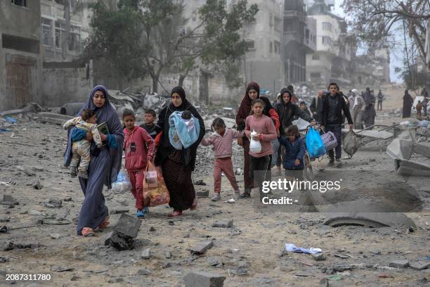 Palestinians flee the area after Israeli bombardment in central Gaza City on March 18 amid the ongoing battles between Israel and the militant group...