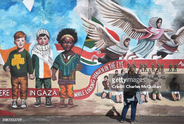 Tourist takes pictures of the Palestinian solidarity murals on the International Wall on the Falls Road on March 18, 2024 in Belfast, Northern...