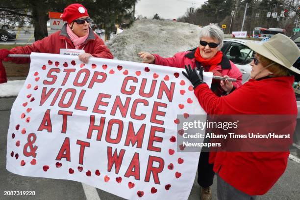 Kim Kennedy, left, of Saratoga Springs, Barbara Spring of Albany and Susan Lozon, at right, of Troy ready a sign as Grannies for Peace celebrate...