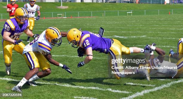 UAlbany defense's Dorian Polk, left, and Olatunji Idowu, at right, bring down the offense's Ryan Spelman during UAlbany football's annual Spring Game...