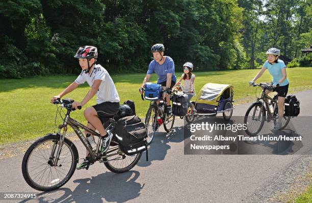 The Scott family, from left, son Sho Charles, daughter Saya and Eiko ride through Vale Park as the bicycle from their home in NYC to Niagara Falls...