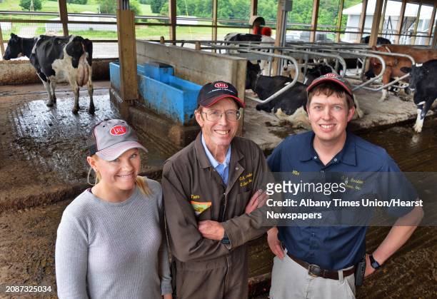 Dairy farmer Tom Borden, center, his daughter Susan and son Mike, right, inside the robot barn at the 177-year-old O.A. Borden & Sons farm Thursday...