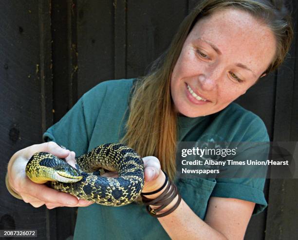 Park educator Rebecca Mullins holds a badly injured adult female eastern hognose snake that she has been nursing back to health at the Moreau Lake...