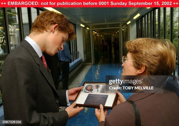 Prince Harry is given a framed picture by Chief Executive, Jane Collins, during his visit to Great Ormond Street Hospital, London, Thursday, 12...
