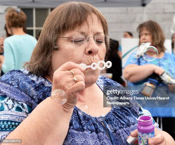 Of Rensselaer County volunteer CarolLynn Langley of Poestenkill blows bubbles during a celebration of ARC's 65th Anniversary Tuesday May 12, 2015 in...