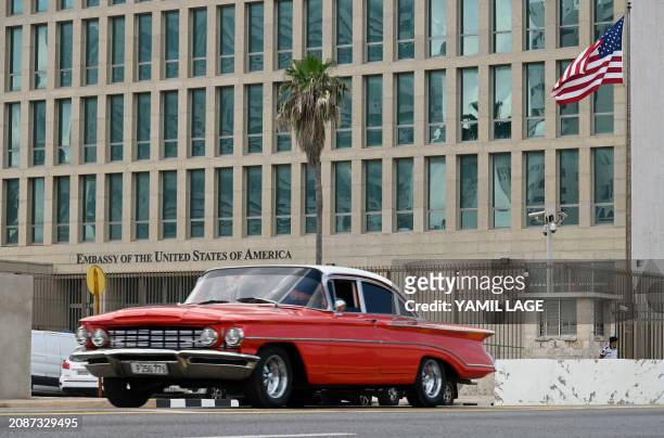 Car drives past the US embassy in Havana, on March 18, 2024. The chargé d'affaires of the US embassy in Havana, Benjamin Ziff, was summoned to the...