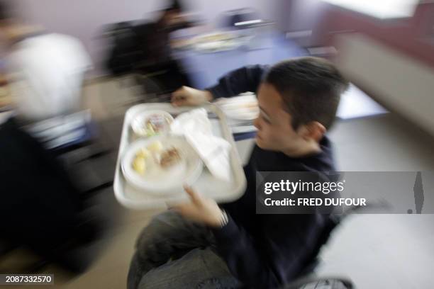 Young handicaped takes away his tray 02 December 2005 at the cantina of Emmanuel de Martonne school in Laval where handicaped kids share their...