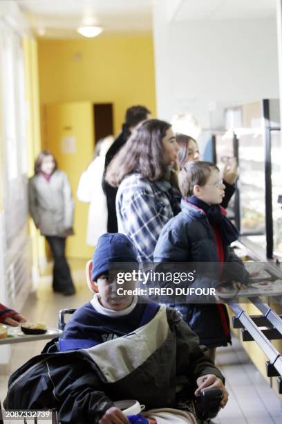 Young pupils take their lunch break at Emmanuel de Martonne school in Laval 02 December 2005 where handicaped kids share their breaks, lunch and...