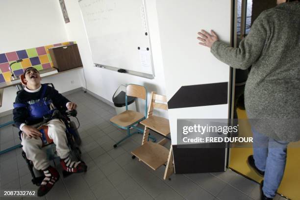 Young handicaped boy is about to leave his class 02 December 2005 at Emmanuel de Martonne school in Laval where handicaped kids share their breaks,...