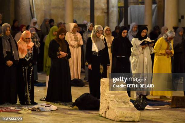 Muslim devotees perform an evening prayer known as 'Tarawih' in the courtyard of the Tunisian capital's historic Zituna mosque in the heart of Tunis'...