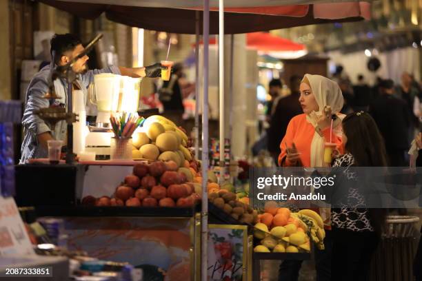 Citizens spend time at the Al-Mutanabbi Street despite rainy weather after iftar dinner during Ramadan in Baghdad, Iraq on March 18, 2024.