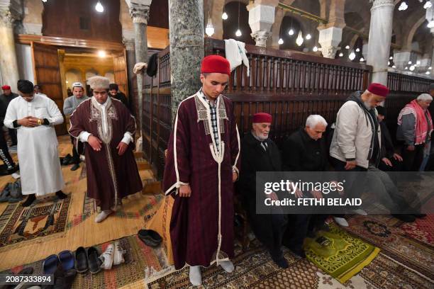 Muslim devotees perform an evening prayer known as 'Tarawih' in Tunisian capital's historic Zituna mosque in the heart of Tunis' old quarter during...