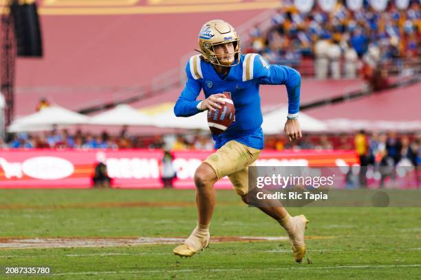 Ethan Garbers of the UCLA Bruins rolls out to pass during a game against the USC Trojans at United Airlines Field at the Los Angeles Memorial...