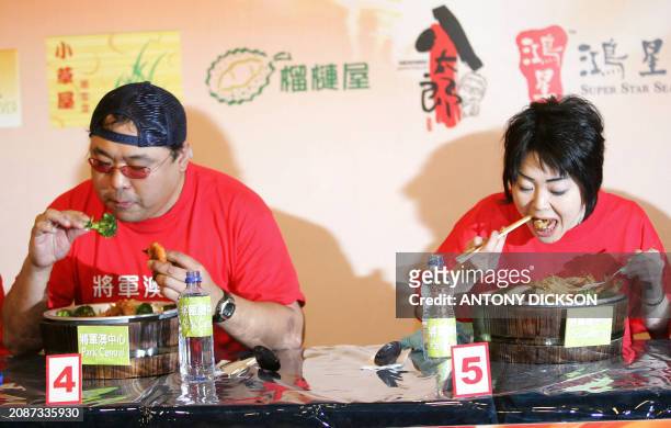 Miyuki Iwata from Japan gorges chinese food as she competes against Johnny Wu of Hong Kong and other competitors in an eating competition in Hong...