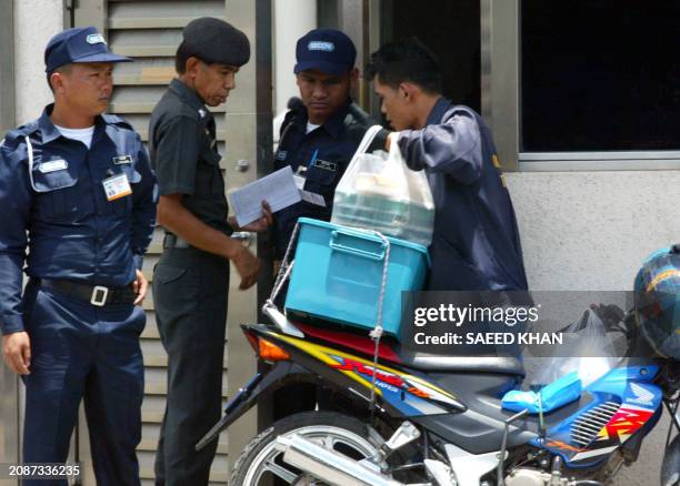 Courier delivers food for the ten suspected North Korean asylum seekers at the gate of the Japanese embassy in Bangkok, 02 August 2003. Ten suspected...