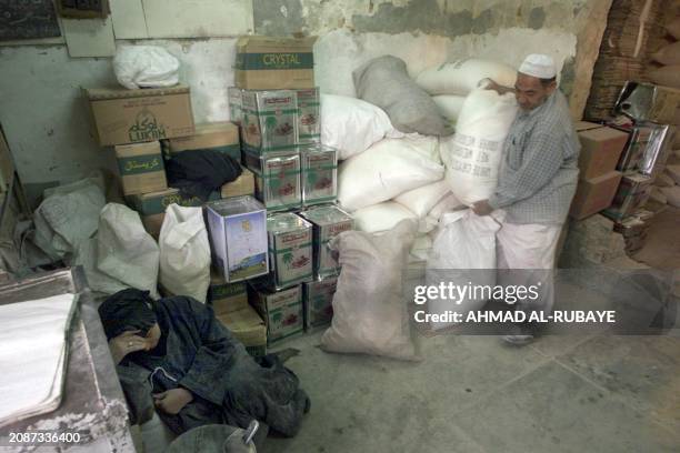 An Iraqi woman rests at a food distribution center in Baghdad 03 April 2003. US troops reached baghdad airport today after fierce fighting with Iraqi...