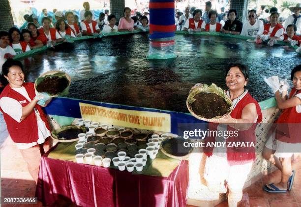 Local residents show off slices from a coconut rice cake measuring five meters in diameter in Candon Ilocos Sur northern Philippines, 30 March 2003....
