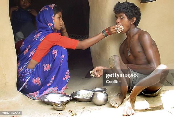 Santosh Kumar Rajvanshi suffering from fluoride chemical poisoning, is being fed by his sister-in-law in the village of Kachhariadih, 12 May 2003,...
