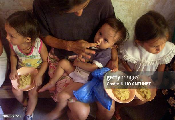 Olga Yanira is fed by her mother thanks to a program created to fight hunger in Orcuina, Honduras 05 October 2002. Olga Yanira es alimentada por su...