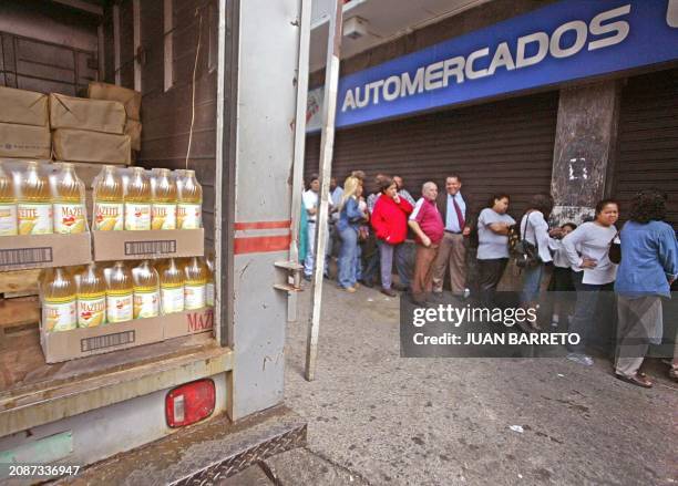 Group of people line up outside the door of a supermarket in Caracas in order to buy food, 14 January 2003. Un grupo de gente hace fila en la puerta...