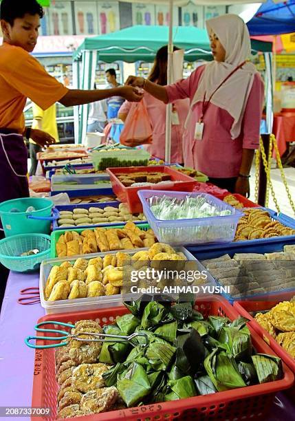 Woman buys traditional sweetmeal, locally known as 'kuih' to break her fast in Kuala Lumpur, 11 November 2002. During the Ramadan month, many food...