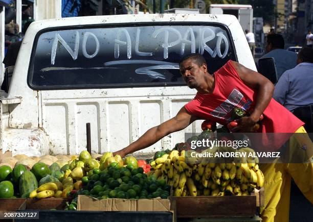 Man sells fruit in a pick up truck with grafitti saying no more strikes in Caracas, 03 December 2002.Venezuela's opposition called on supporters to...