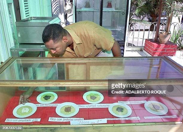 Alberto Gonzalez, owner of "El Jardin" restaurant in La Habana, Cuba is seen placing tacos on dispaly 23 April 2002. Alberto Gonzalez, administrador...