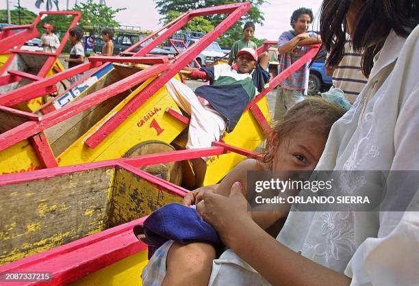 Mother is seen nursing her child after having picked trashed in Managua, Nicaragua 29 October 2001. ACOMPANA NOTA: "ECONOMIA EXANGUE, DESEMPLEO Y...