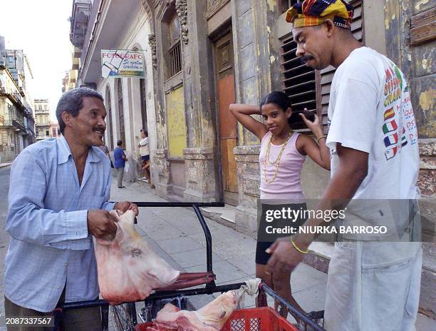 Cuban priest Jose Bencomo buys a pig's head in Havana, Cuba 31 December 2001. Jose Bencomo , sacerdote de la religion afrocubana Yoruba, compra una...