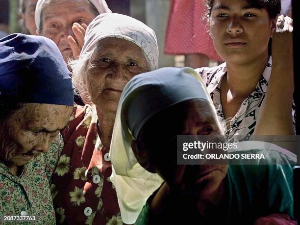 Women of Talnique, 48 kms southwest of San Salvador, El Salvador, wait to receive foods 18 January 2001 after the earthquake hit this area. Mujeres...