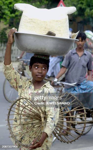 Ariful Islam, a 14-year old food-vendor, searches for customers in the Bangladeshi capital of Dhaka, 20 July 2001. Islam, who's main customers are...