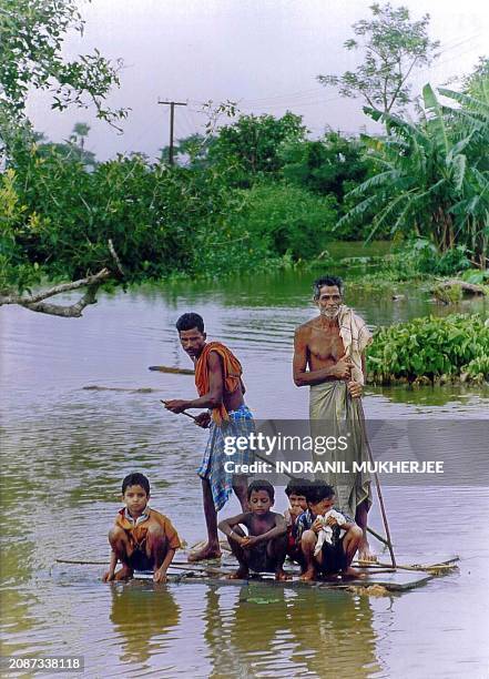 Family head for safety on a makeshift raft in Jajpur district, 60 kms east of Orissa capital Bhubaneswar, 22 July, 2001. India's rain-battered state...