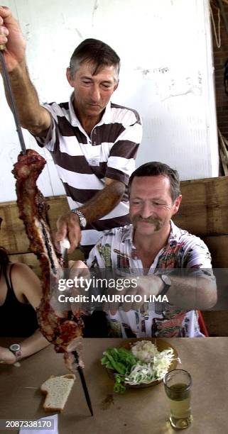 Jose Bove French farmer leader and antigobalization activist is eating a Brazilian barbecue during a visit to members of a farming movement, Workers...