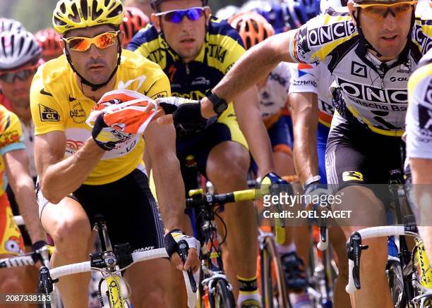 Spanish Abraham Olano gives food to his teammate,the yellow jersey Frenchman Laurent Jalabert, as they ride among the pack during the 6th stage of...