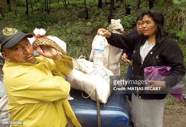 Woman offers her husband water as they help the community of Xilotzingo, by bringing food, Mexico, 10 October 1999. Un hombre se prepara, cuando su...